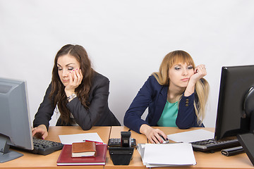 Image showing Two young office employee tired of working at computers