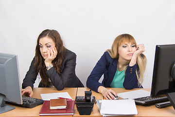 Image showing Two young employee of the office behind a desk looking sadly into the frame