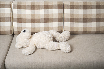 Image showing Teddy bear is laying on the sofa