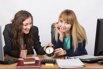 Image showing  Two girls in the office happily waiting for the end of the working day