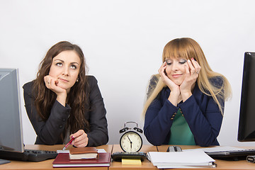 Image showing Two employee in the office waiting for the end of working hours on the clock