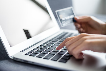 Image showing Woman holding credit card and using computer for online shopping