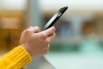 Image showing Woman uses her smart phone on the street