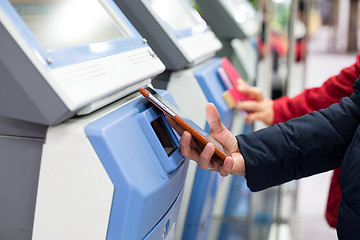 Image showing Woman using cellphone for paying her ticket