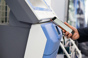 Image showing Woman scanning discount coupon in ticketing machine