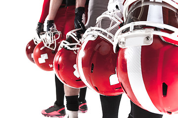 Image showing The hands of american football players with helmets on white background