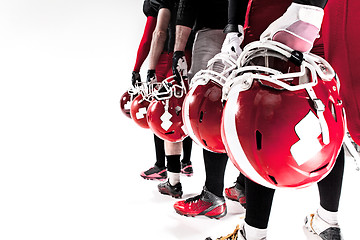 Image showing The hands of american football players with helmets on white background