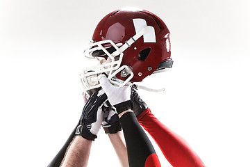 Image showing The hands of american football players with helmet on white background