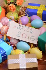 Image showing Arrangement of Gift Boxes in Wrapping Paper with Checkered Ribbons and Decorated Easter Eggs isolated on white background