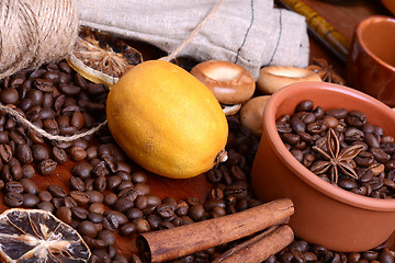 Image showing orange and lemon, coffee beans and cinnamon on wooden brown background.