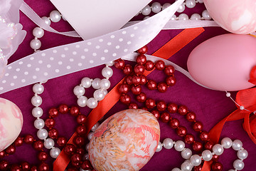 Image showing Painted Easter eggs decorated with flowers with pearls in a basket on an old table