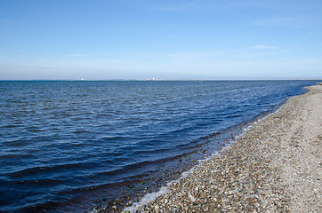 Image showing Shoreline with blue water and pebbles