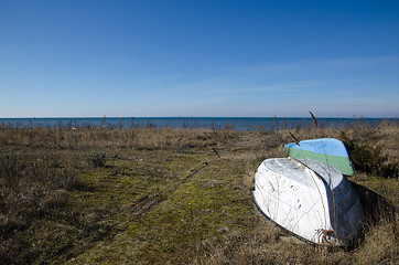 Image showing Small rowing boats up-side-down by the coast