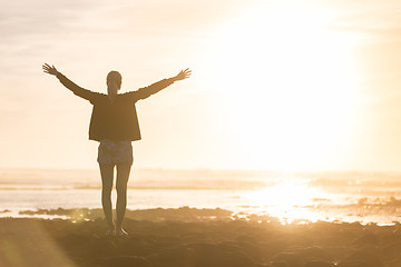 Image showing Free woman enjoying freedom on beach at sunset.