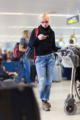 Image showing Female traveler using cell phone while waiting on airport.