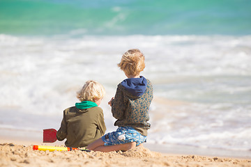 Image showing Boys playing with toys on beach.