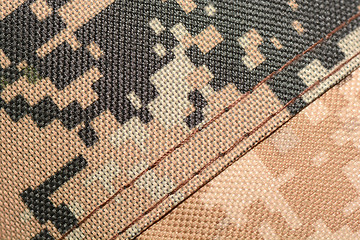 Image showing close up of worn out olive green tone camouflage fabric