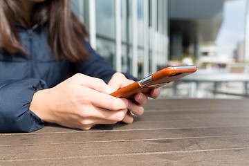 Image showing Woman play game on cellphone at outdoor cafe