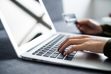 Image showing Hands holding credit card and using laptop