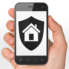 Image showing Finance concept: Hand Holding Smartphone with Shield on display