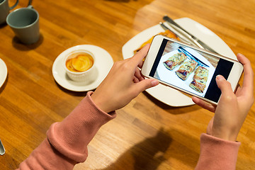 Image showing Woman use of the cellphone for taking the picture of the food