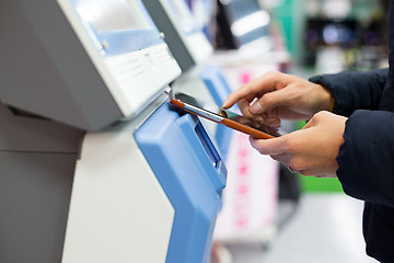 Image showing Woman using cellphone for paying on machine