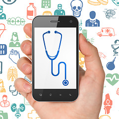 Image showing Health concept: Hand Holding Smartphone with Stethoscope on display