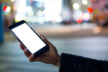 Image showing Woman hand holding cellphone at city night