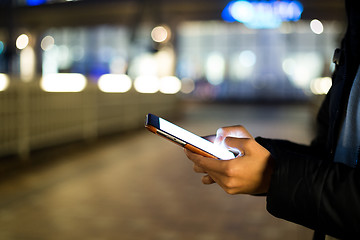 Image showing Woman typing on cellphone at street