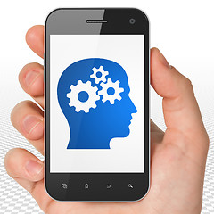 Image showing Education concept: Hand Holding Smartphone with Head With Gears on display