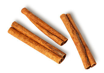 Image showing Three cinnamon sticks lie nearby