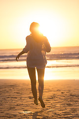 Image showing Woman running on the beach in sunset.