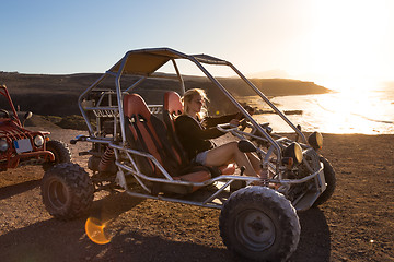 Image showing Woman driving quadbike in sunset.