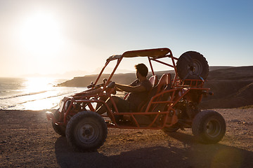 Image showing Man driving quadbike in sunset.