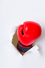 Image showing Hand in boxing glove through paper hole