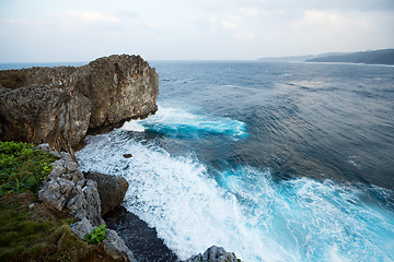 Image showing Waves crashing over rock formation cliff
