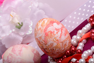 Image showing Painted Easter eggs decorated with flowers with pearls in a basket on an old table