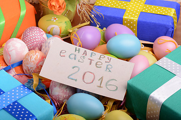 Image showing Arrangement of Gift Boxes in Wrapping Paper with Checkered Ribbons and Decorated Easter Eggs isolated on white background