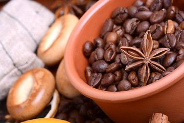 Image showing orange and lemon, coffee beans and cinnamon on wooden brown background.