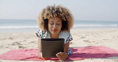 Image showing Woman Uses A Tablet On The Beach