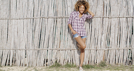 Image showing Young Woman Near A Wattled Fence