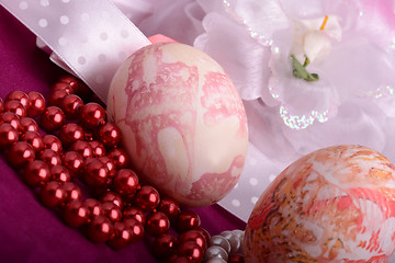 Image showing Painted Easter eggs decorated with flowers with pearls in a basket on an old table