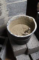Image showing A bucket with a solution and a trowel, close-up