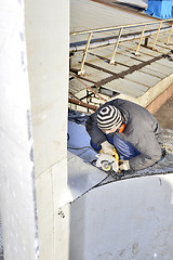 Image showing Unidentified worker cutting sheet metal electric hand tool on th