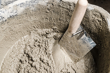 Image showing A bucket with a solution and a trowel, close-up