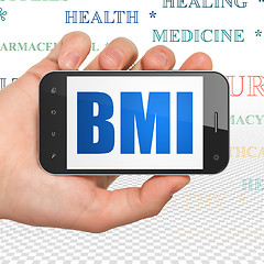 Image showing Medicine concept: Hand Holding Smartphone with BMI on display