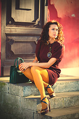 Image showing woman in a burgundy dress sitting on the old porch