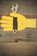 Image showing yellow safety glove and a pipe wrench