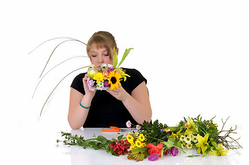 Image showing Young girl arranging flowers