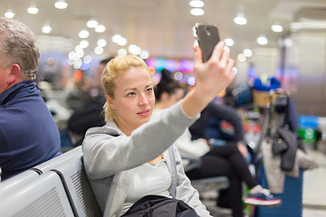 Image showing Female traveler taking selfie on airport.